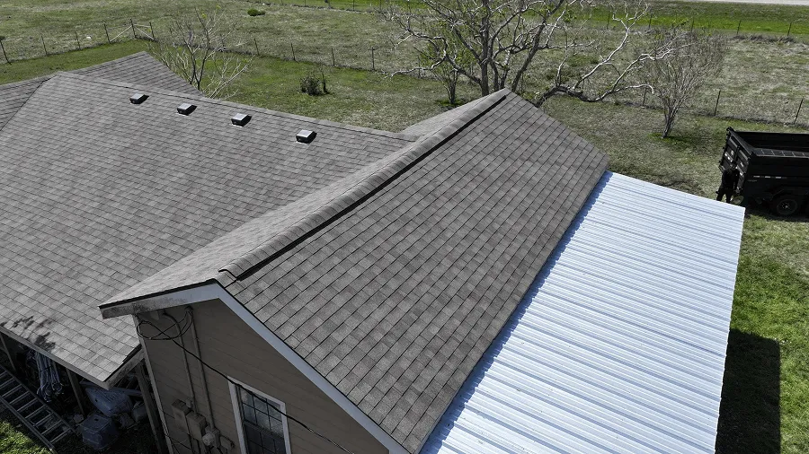 Asphalt shingle and standing-seam metal roof sections on one Central Texas home