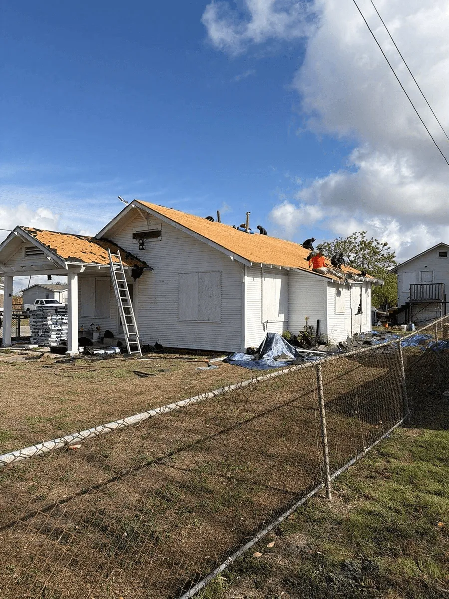 OSAAT crew tearing off a storm-damaged roof with the home boarded up